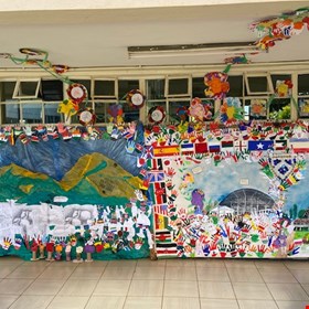 melted plastic landscape with year 7 sheep drawings and nursery and year 1 students flowers and primary hands